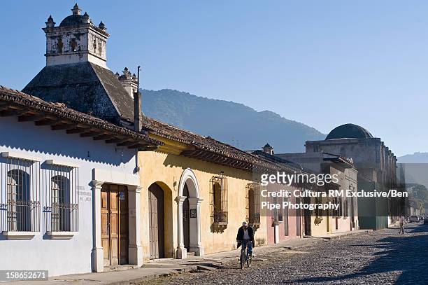 colorful buildings on city street - antigua western guatemala stock pictures, royalty-free photos & images