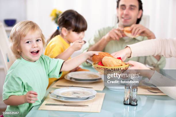 happy family of four eating soup for lunch - eating soup stock pictures, royalty-free photos & images