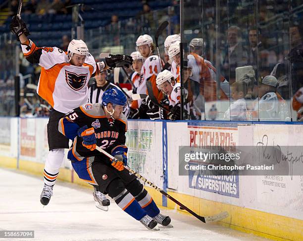 Zac Rinaldo of the Adirondack Phantoms leaps out of the way of Jordan Hill of the Bridgeport Sound Tigers as they play for possession of the puck...