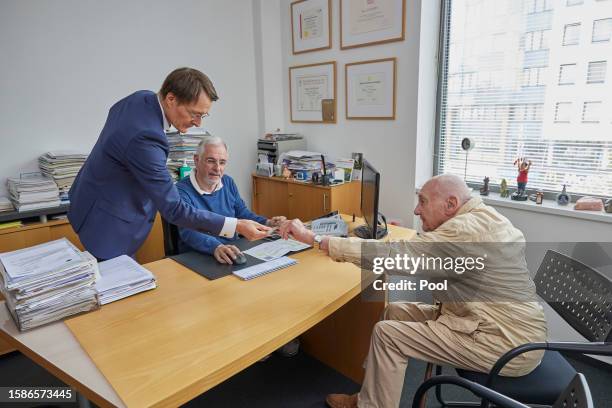 German Health Minister Karl Lauterbach accepts the health insurance card of 86-year-old Peter Jordan , to enable doctor Benny Levenson to be able to...