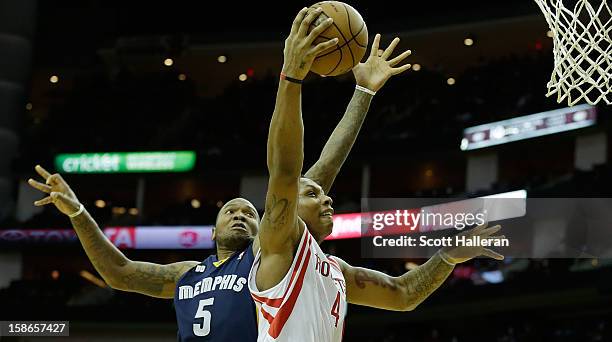 Greg Smith of the Houston Rockets drives against Marreese Speights of the Memphis Grizzlies at the Toyota Center on December 22, 2012 in Houston,...