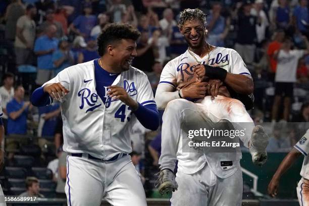 Melendez of the Kansas City Royals celebrates with Carlos Hernandez and Salvador Perez after scoring on a walk-off balk in the the 10th inning...