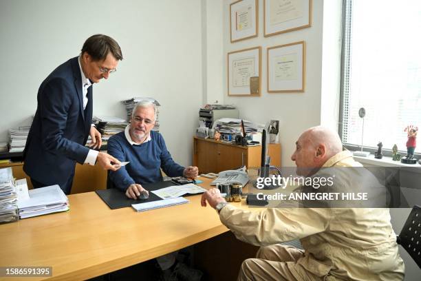 German Health Minister Karl Lauterbach checks a health card of patient Peter Jordan as cardiologist Benny Levenson looks on, during a presentation of...