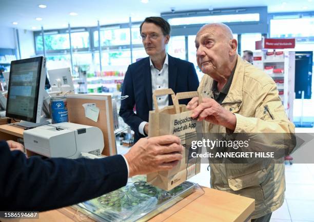 Patient Peter Jordan buys medication at a pharmacy next to German Health Minister Karl Lauterbach, during a presentation of the new process for...