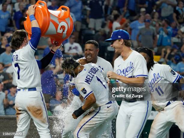 Melendez of the Kansas City Royals is doused with water by Bobby Witt Jr. #7 as he celebrates with teammates after scoring on a walk-off balk in the...