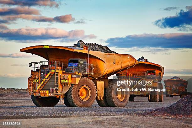 dump trucks dumping rocks at a gold mine - banagan dumper truck stock pictures, royalty-free photos & images