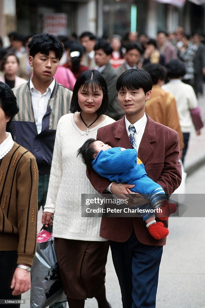 Only One Child One Child Family - A proud mother and father carry their child along ...