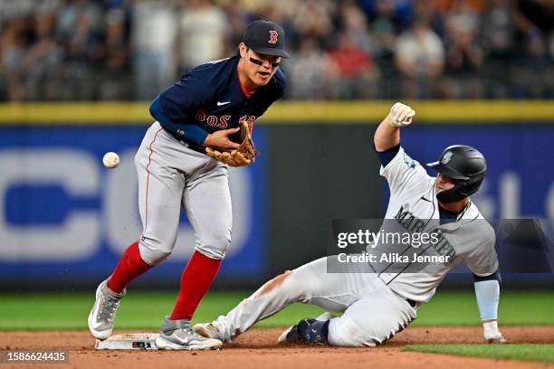 Ty France of the Seattle Mariners slides to second base against Yu Chang of the Boston Red Sox at T-Mobile Park on August 01, 2023 in Seattle,...