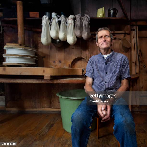 swiss traditional cheesemaker smiling in wooden farmhaus. - dairy cultures stock pictures, royalty-free photos & images