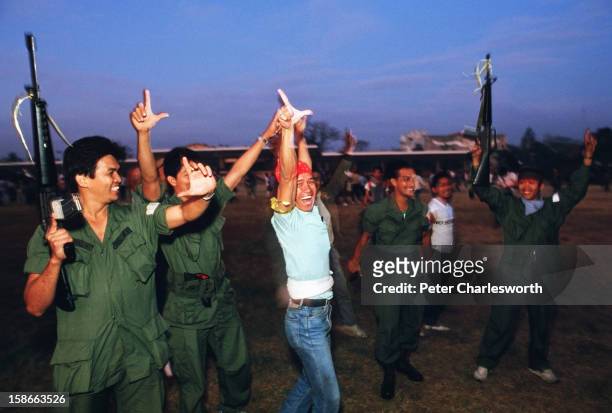 Philippine soldiers celebrate the arrival of helicopters and their pilots at the military base, Camp Crame. These soldiers and pilots were once loyal...
