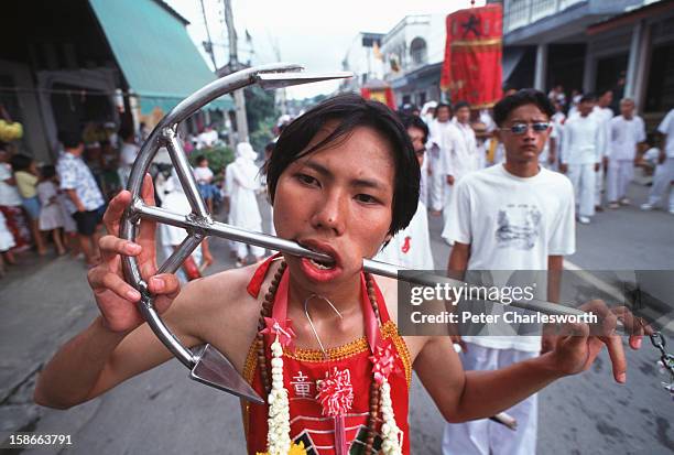 Devotee walks in a parade through the streets of Phuket Town during the annual vegetarian festival which is an observance of Taoist Lent. It is so...