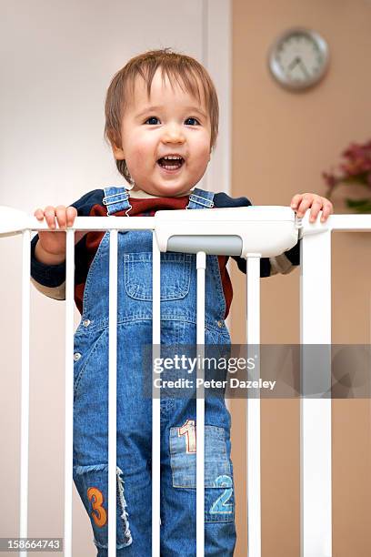 young boy at a stair gate - baby gate stock pictures, royalty-free photos & images