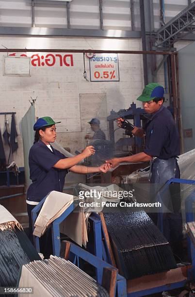 Workers on the production line at the Siam V.M.C. Safety Glass Company. The company specialises in manufacturing windows including windscreens for...