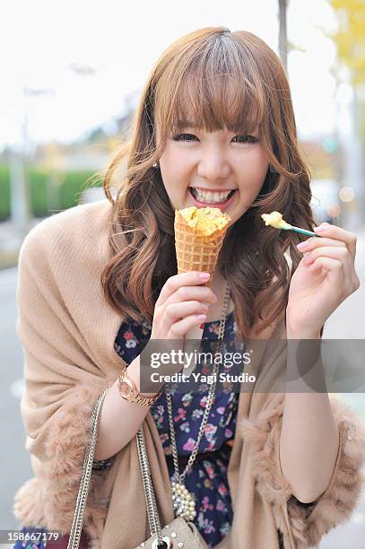 young woman is eating ice cream - woman in a shawl stock pictures, royalty-free photos & images