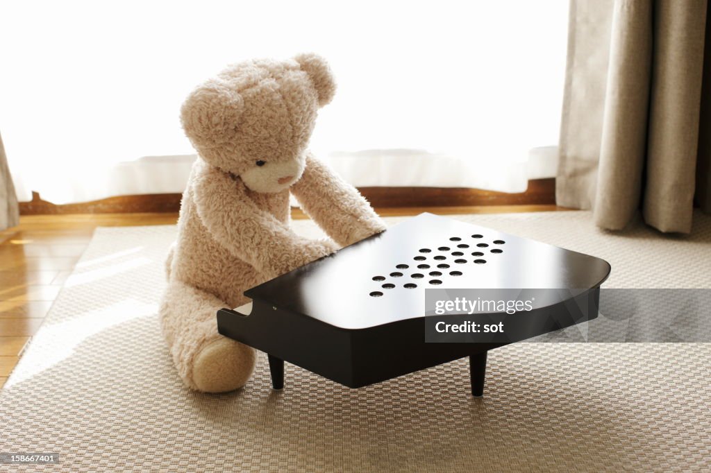 Teddy bear playing small piano