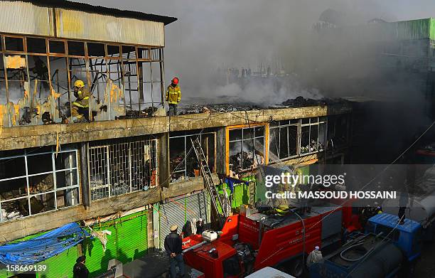 Afghan firefighters attempt to control a fire that swept through a market in Kabul on December 23, 2012. A huge fire swept through a market in...