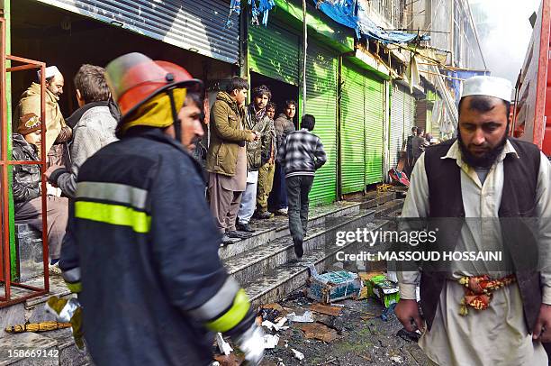 An Afghan firefighter walks through a market that was destroyed by a fire in Kabul on December 23, 2012. A huge fire swept through a market in...