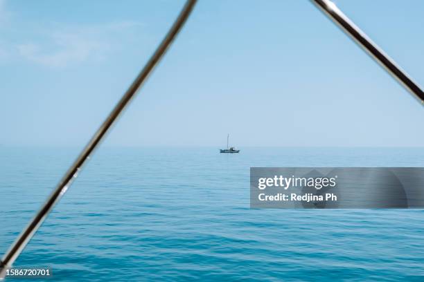 beauty of the ocean or sea with a yacht on horizon line. water texture, tranquil scene - luxury yacht stock pictures, royalty-free photos & images