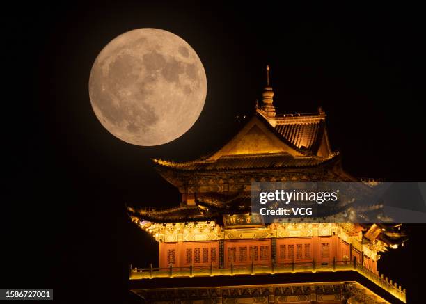 Super moon rises over a tower on August 1, 2023 in Jiujiang, Jiangxi Province of China.