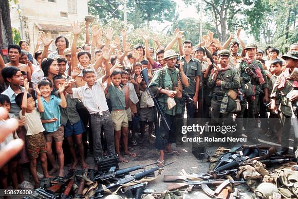 The fall of Phnom Penh. Victorious Khmer Rouge soldiers are cheered on by a crowd of youngsters, opposite the French embassy..