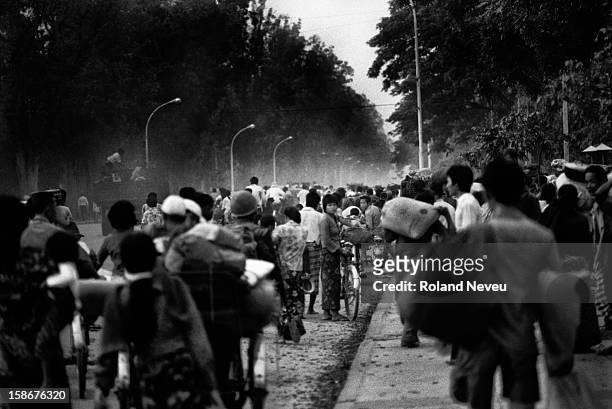 On the eve of the Fall of Phnom Penh to the Khmer Rouge on April 16, 1975 as night fall, thousands of people are streaming towards the center of...