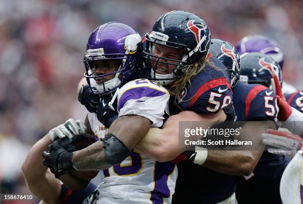 Adrian Peterson of the Minnesota Vikings is stopped by Bradie James and Brooks Reed of the Houston Texans at Reliant Stadium on December 23, 2012 in...