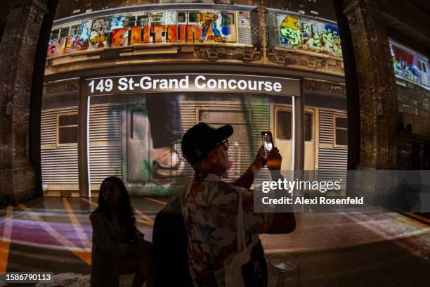 Man takes a video on his iphone at the opening night preview of the new ‘Hip Hop Til Infinity’ immersive art installation at Hall des Lumières on...
