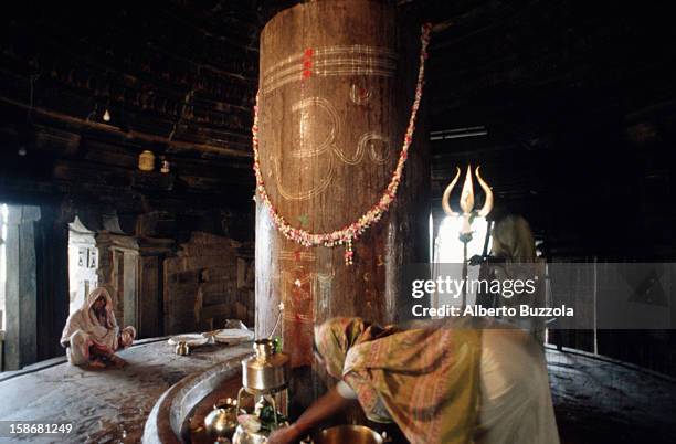 Woman performing Puja, an offering of milk, water and flowers, to Lord Shiva inside Matangeswara temple..