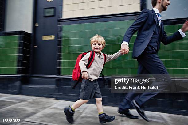 father and son running to school - enfant cartable photos et images de collection
