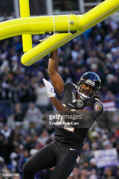 Wide receiver Torrey Smith of the Baltimore Ravens hangs on the goal post after catching a touchdown pass during the first quarter against the New...