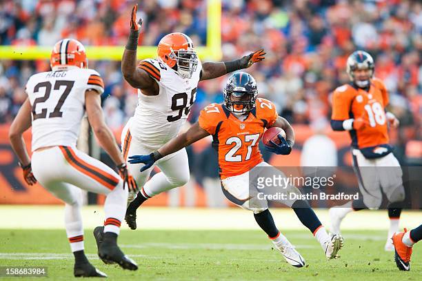 Running back Knowshon Moreno of the Denver Broncos rushes as defensive end Juqua Parker of the Cleveland Browns attempts the tackle at Sports...