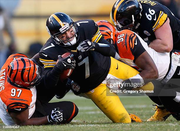 Ben Roethlisberger of the Pittsburgh Steelers is tackled during the fourth quarter by Geno Atkins and Carlos Dunlap of the Cincinnati Bengals at...