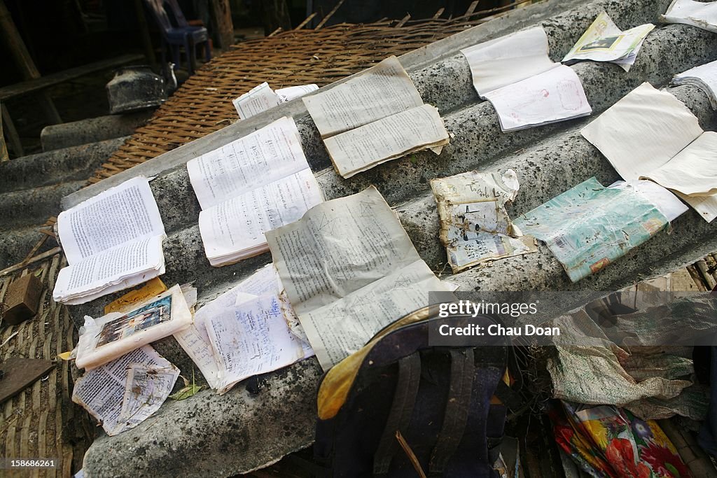 School books are laid out to dry on the roof of a collapsed...
