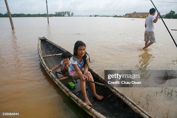 Vietnamese sisters Ly Thi Uyen and Ly Thi My and their father Le Van Quy wait for instant noodles handout by the local authority in Trung Don...