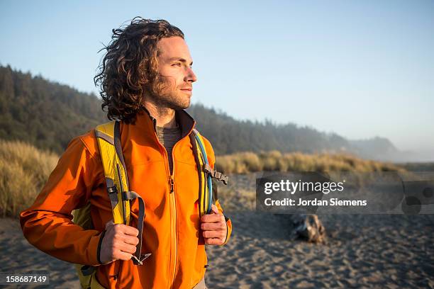 man hiking near the ocean. - man adventure fotografías e imágenes de stock