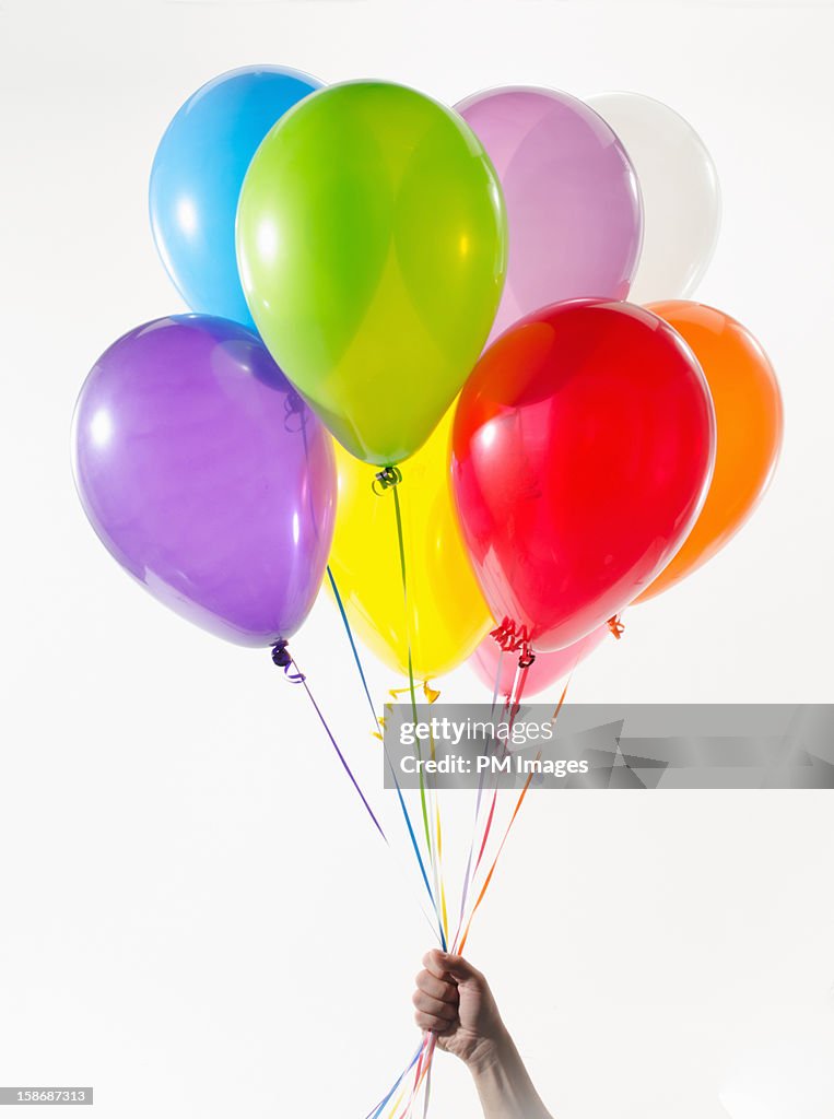 Hand holding colorful balloons