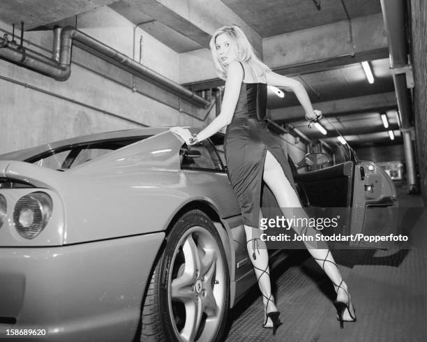English actress Lisa Faulkner poses with a Ferrari F355 Berlinetta, in 1996.