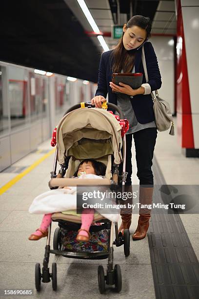 business lady talking on mobile pushing stroller - baby boot stock pictures, royalty-free photos & images