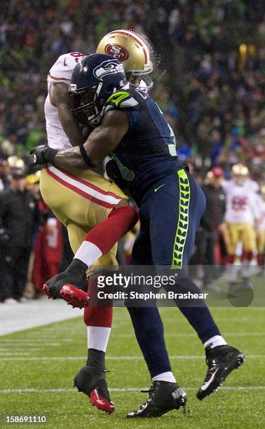 Kam Chancellor of the Seattle Seahawks hits Vernon Davis of the San Francisco 49ers during a game at CenturyLink Field on December 23, 2012 in...