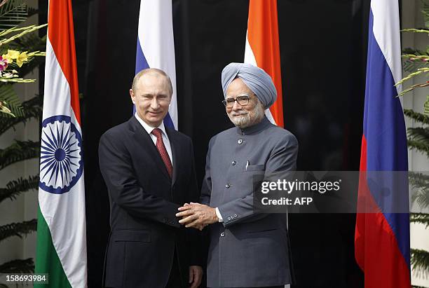 Russian President Vladimir Putin shakes hands with Indian Prime Minister Manmohan Singh ahead of a meeting at Singh's residence in New Delhi on...