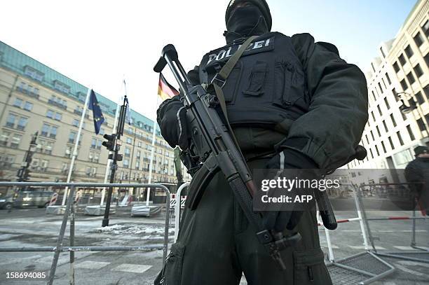 An armed German policeman stands guard in front of the Pariser Platz on January 25, 2010 in Berlin, after the place was closed to the public for...