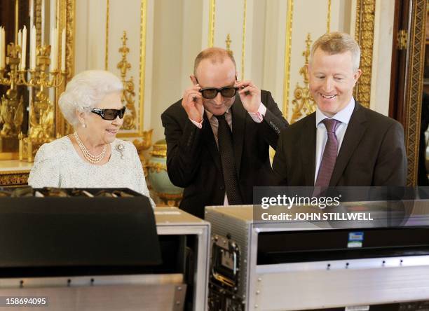 This picture taken on December 7, 2012 Queen Elizabeth II TV producer John McAndrew and director John Bennett watch the recording of her Christmas...