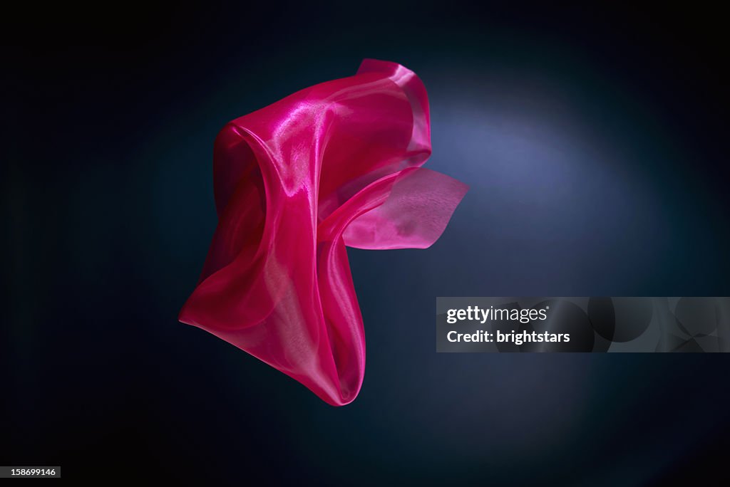 Floating red silk on a dark blue background