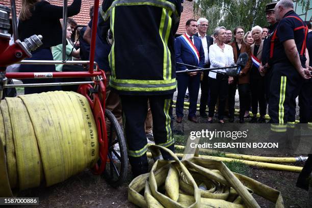 French Prime Minister Elisabeth Borne speaks with a firefighter taking part in the rescue operations after a fire erupted at a holiday home for...