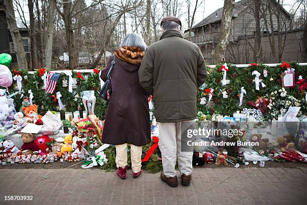 Couple stand in silence a memorial for those killed in the school shooting at Sandy Hook Elementary School, on December 24, 2012 in Newtown,...