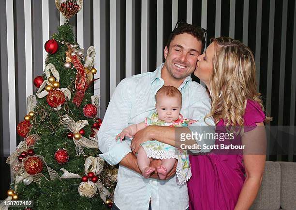 Ed Cowan of Australia is kissed by his wife Virginia Lette as he holds their baby Romy Cowan as they pose next to a Christmas tree ahead of a Cricket...