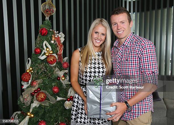 Peter Siddle of Australia and partner Anna Weatherlake pose next to a Christmas tree ahead of a Cricket Australia Christmas Day lunch at Crown...