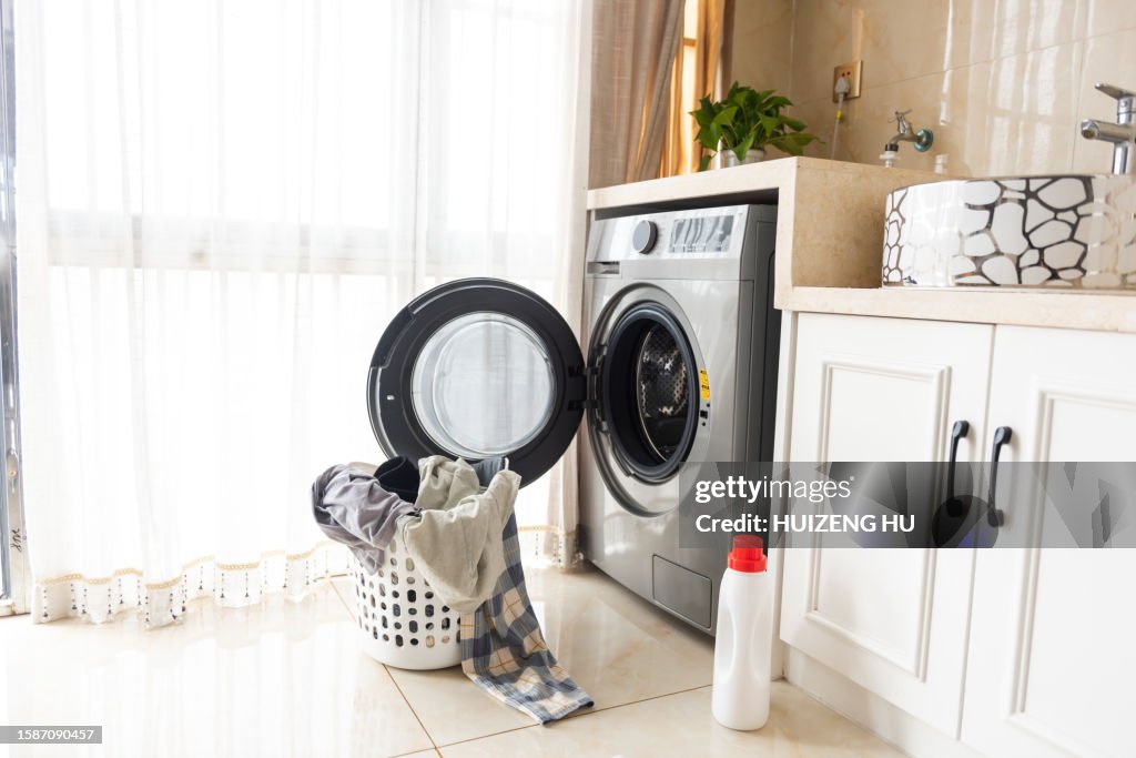 Asian man using washing machine at home. Laundry day