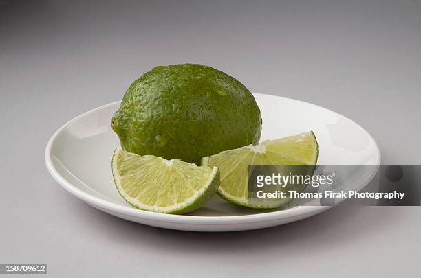 whole lime and 2 wedges -  firak stock pictures, royalty-free photos & images