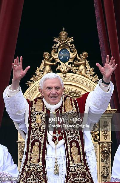 Pope Benedict XVI waves to the faithful as he delivers his Christmas Day message from the central balcony of St Peter's Basilica on December 25, 2012...